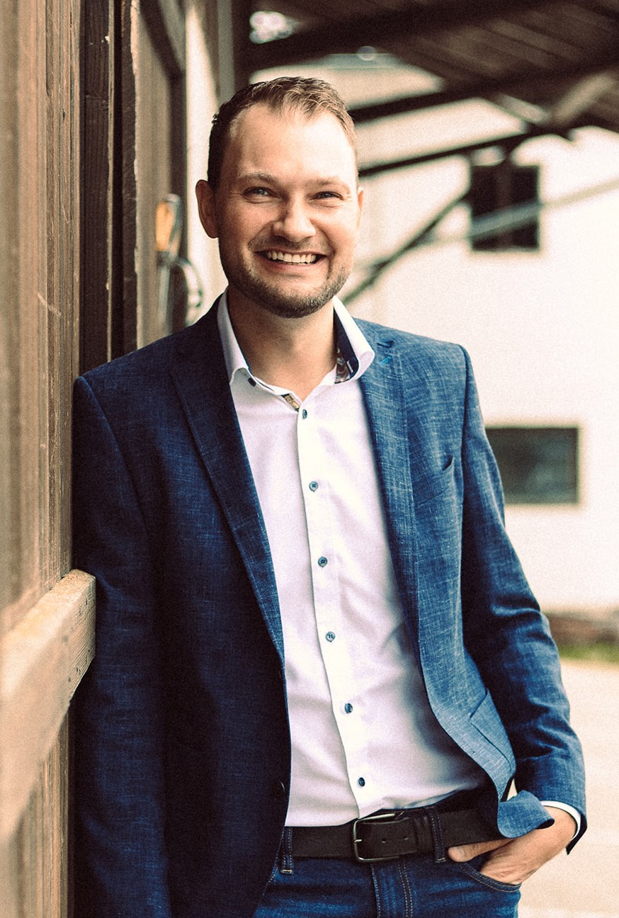 Christian Liebhart, Coach für Führungskräfte, steht vor einer digitalen Tafel und erklärt seinen Coachees etwas.